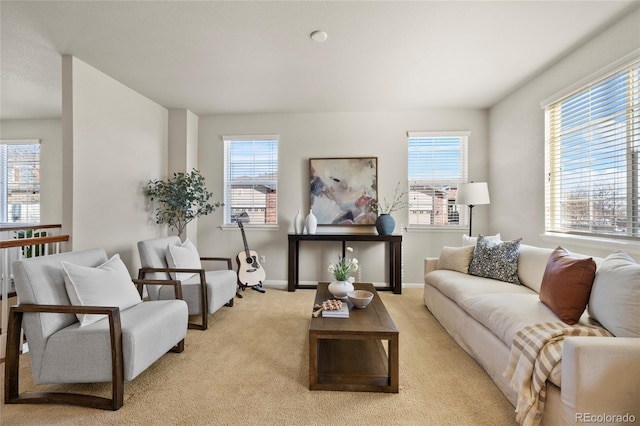 living room featuring light carpet, baseboards, and a wealth of natural light