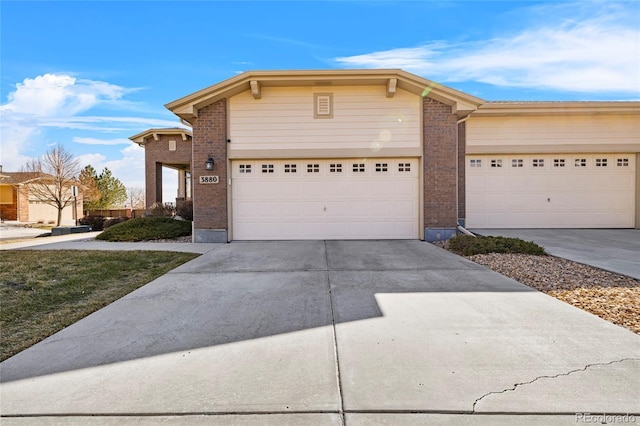 view of front of house featuring driveway and brick siding