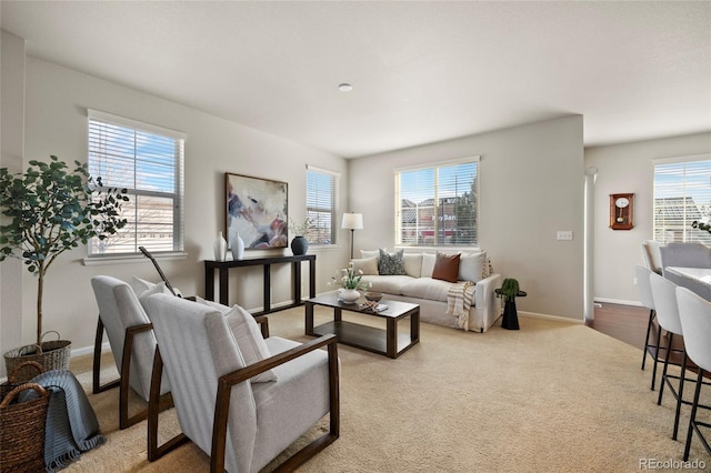 living room with a healthy amount of sunlight, baseboards, and carpet floors