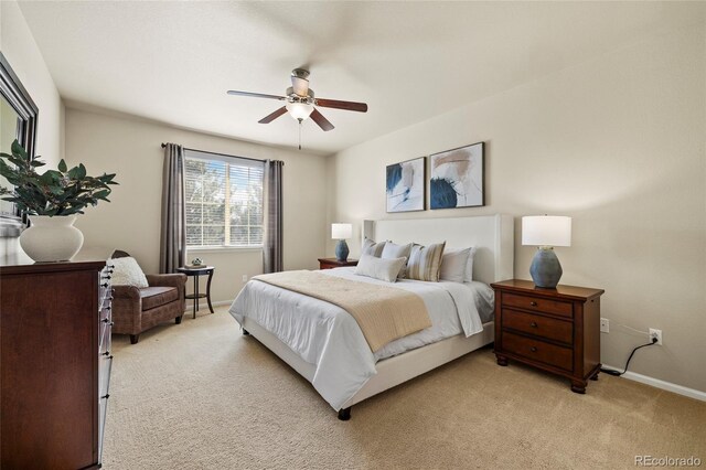 bedroom featuring light carpet, ceiling fan, and baseboards