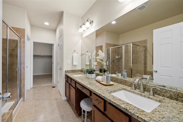 bathroom featuring a stall shower, visible vents, and a sink