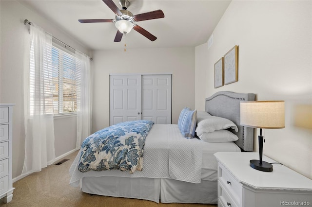 bedroom with light carpet, a ceiling fan, visible vents, and a closet