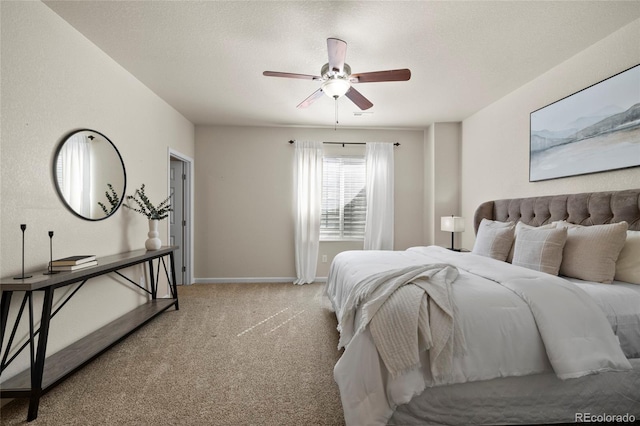 carpeted bedroom with ceiling fan, a textured ceiling, and baseboards