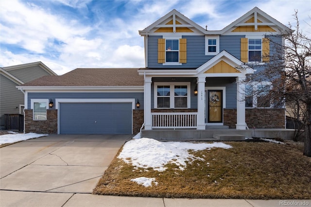 craftsman-style home featuring a garage, concrete driveway, stone siding, covered porch, and board and batten siding