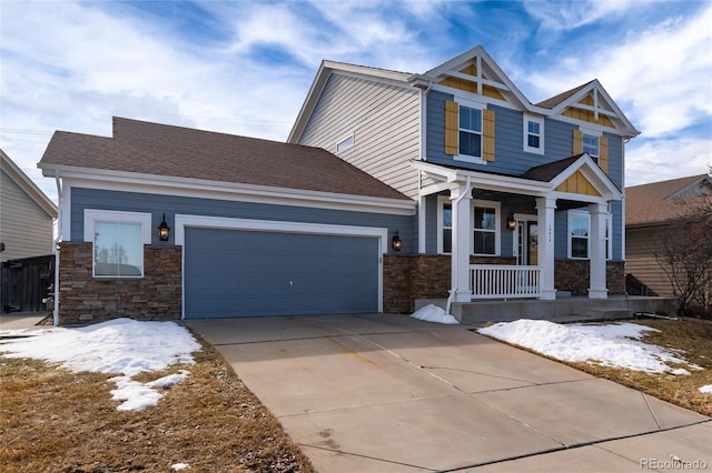 craftsman inspired home featuring stone siding, covered porch, driveway, and an attached garage