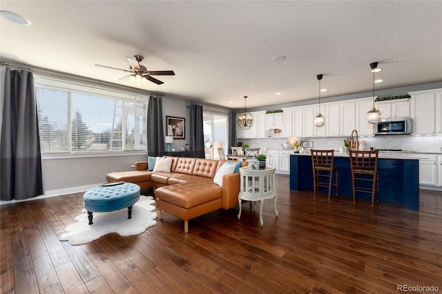 living room with baseboards, dark wood-type flooring, a ceiling fan, and recessed lighting