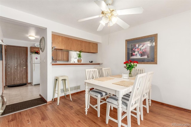 dining room featuring visible vents, light wood-type flooring, and baseboards