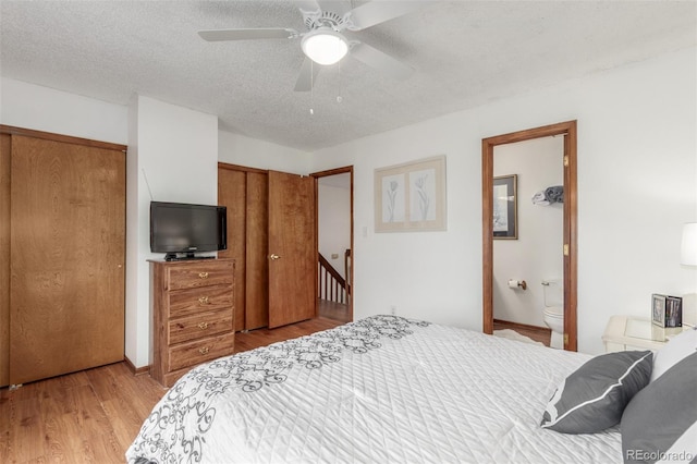 bedroom with ensuite bath, light wood-style flooring, ceiling fan, a closet, and a textured ceiling