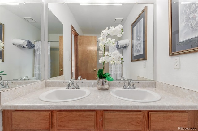 full bath featuring double vanity, visible vents, and a sink