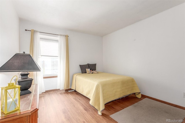 bedroom featuring baseboards and wood finished floors