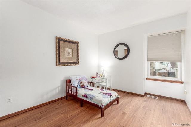 sitting room with visible vents, light wood-style floors, and baseboards