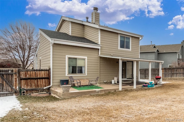 back of house with a gate, fence, roof with shingles, a chimney, and a patio area