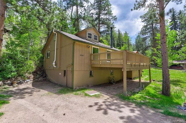 view of side of home featuring a yard and a wooden deck