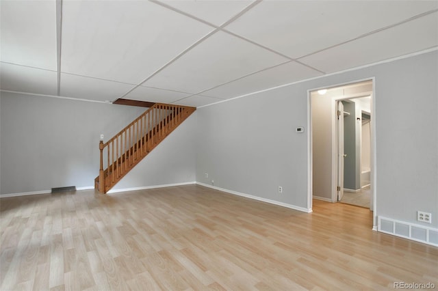 unfurnished living room with light wood-type flooring and a drop ceiling