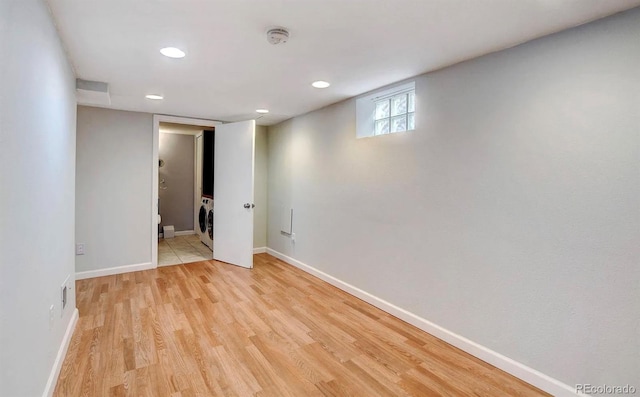 empty room featuring washer / clothes dryer and light hardwood / wood-style flooring