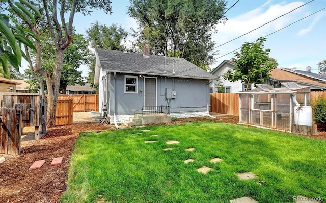 rear view of house with an outbuilding and a lawn