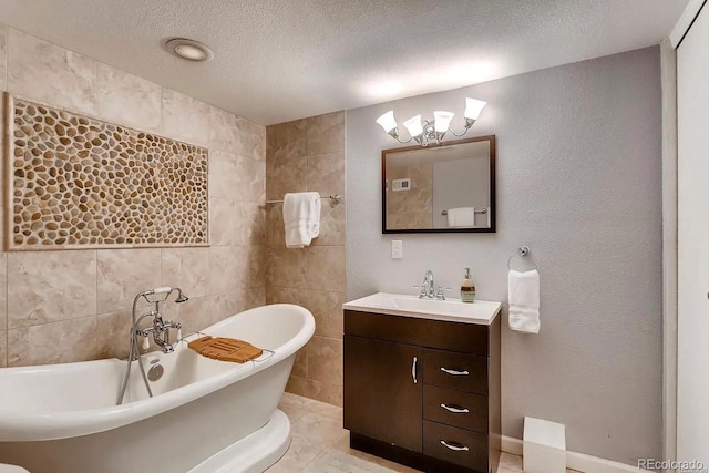 bathroom featuring tile walls, vanity, a textured ceiling, tile patterned floors, and a bathing tub