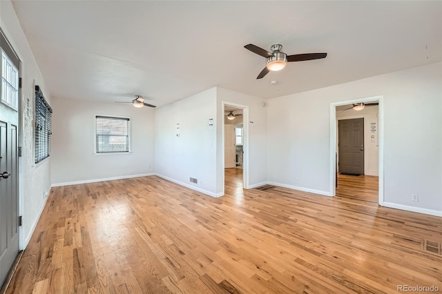 interior space with a ceiling fan, visible vents, baseboards, and light wood-type flooring