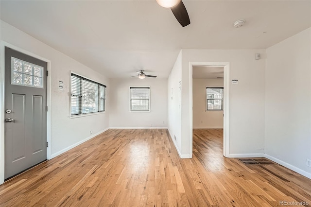 foyer entrance featuring baseboards, a ceiling fan, and light wood finished floors