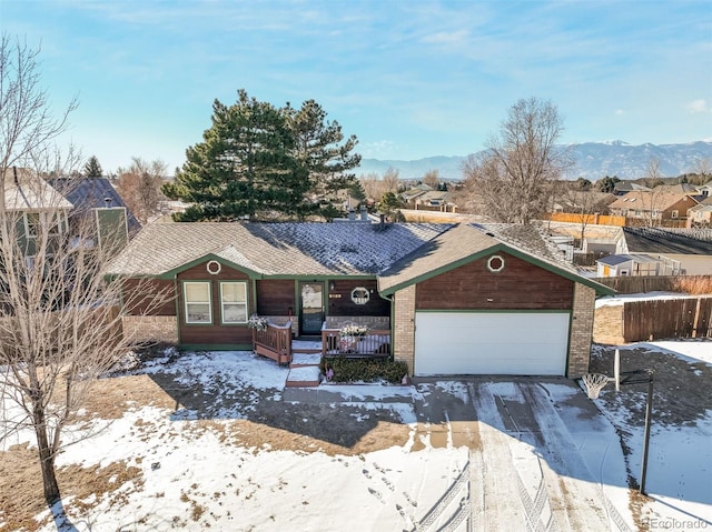 ranch-style house featuring brick siding, an attached garage, a residential view, a porch, and a mountain view