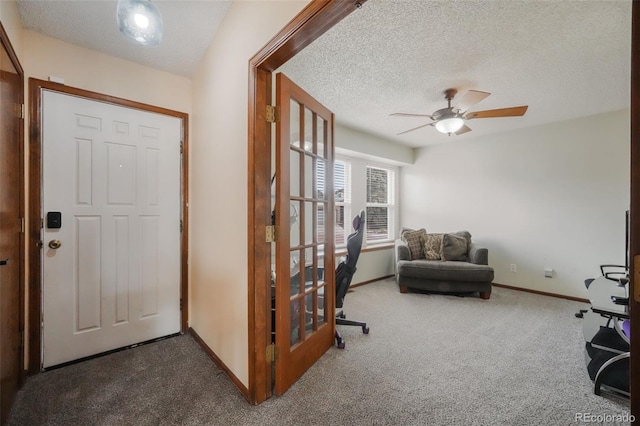 entrance foyer with baseboards, carpet, and a textured ceiling