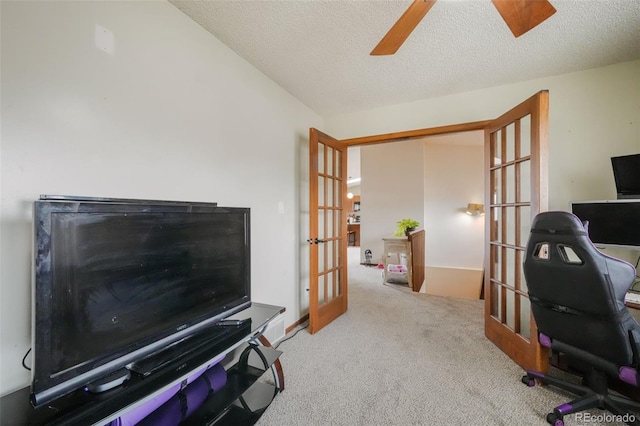 carpeted home office featuring french doors, a textured ceiling, and a ceiling fan