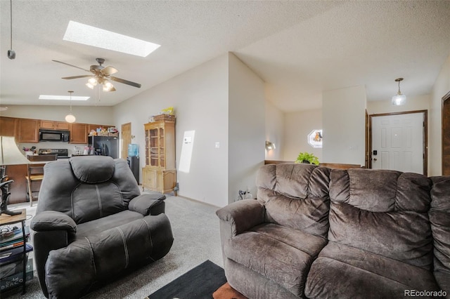 living room with lofted ceiling with skylight, light colored carpet, ceiling fan, and a textured ceiling