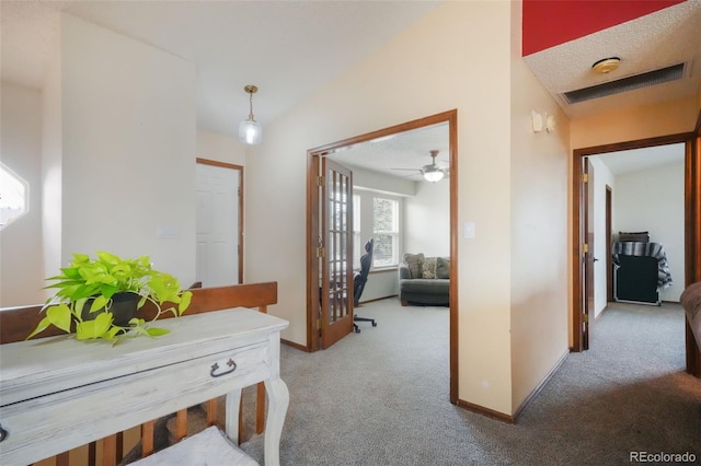 corridor featuring baseboards, lofted ceiling, and carpet flooring