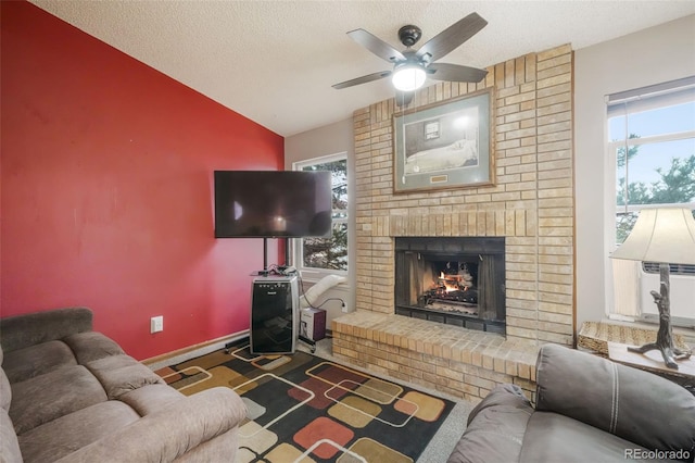 living area featuring plenty of natural light, a brick fireplace, a textured ceiling, and lofted ceiling