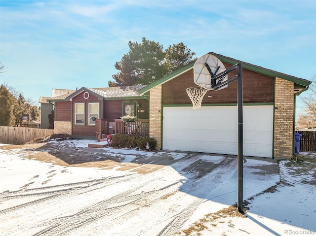 view of front facade featuring driveway, central AC, fence, a garage, and brick siding