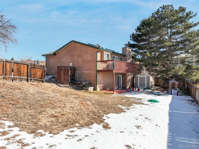 rear view of house featuring a fenced backyard, a shed, stucco siding, and an outdoor structure