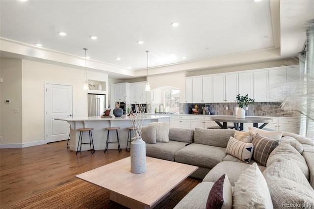 living room with dark hardwood / wood-style flooring and a tray ceiling