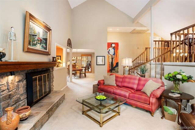 living room with high vaulted ceiling, a chandelier, light carpet, and a stone fireplace