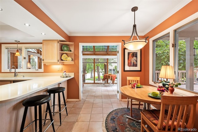 tiled dining room featuring crown molding, plenty of natural light, and sink