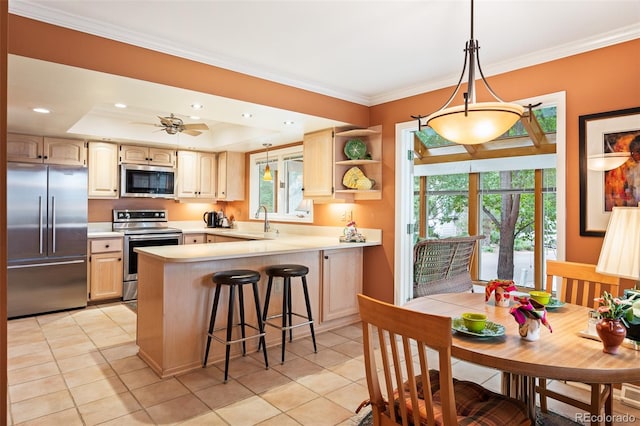 kitchen featuring light brown cabinetry, kitchen peninsula, appliances with stainless steel finishes, and a healthy amount of sunlight