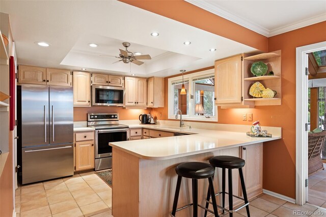 kitchen with kitchen peninsula, light brown cabinetry, ceiling fan, and stainless steel appliances