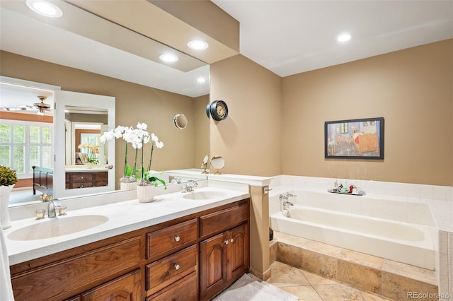 bathroom with vanity, a relaxing tiled tub, and tile patterned flooring