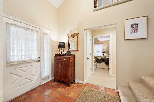 entryway featuring carpet and a towering ceiling