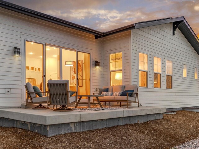 back of property at dusk with an outdoor hangout area