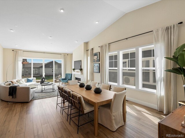 dining area featuring baseboards, lofted ceiling, and hardwood / wood-style floors