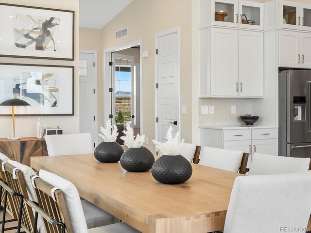 dining room featuring visible vents and vaulted ceiling