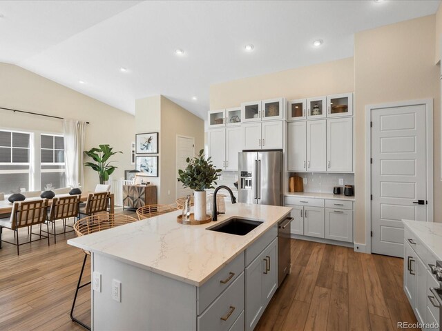 kitchen with a sink, appliances with stainless steel finishes, tasteful backsplash, and hardwood / wood-style floors
