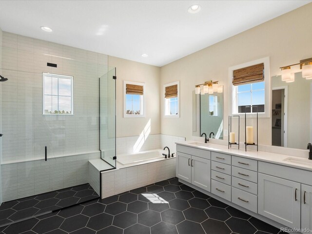 bathroom featuring double vanity, a shower stall, a sink, and a bath