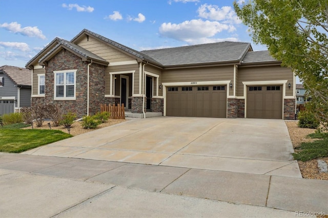 view of front of property with stone siding, an attached garage, and concrete driveway