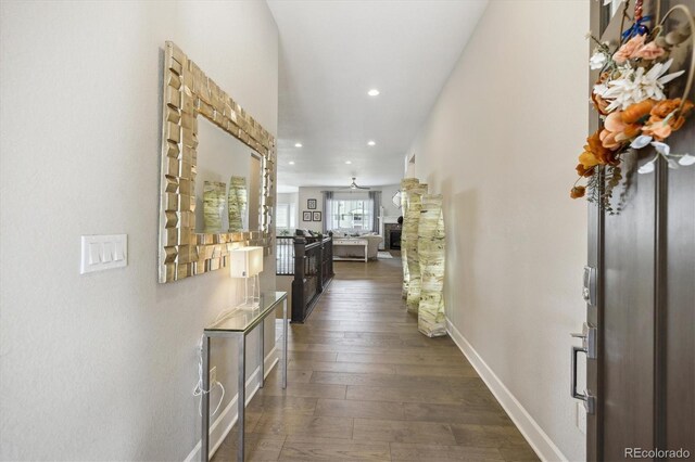 corridor with dark wood-style flooring, recessed lighting, and baseboards