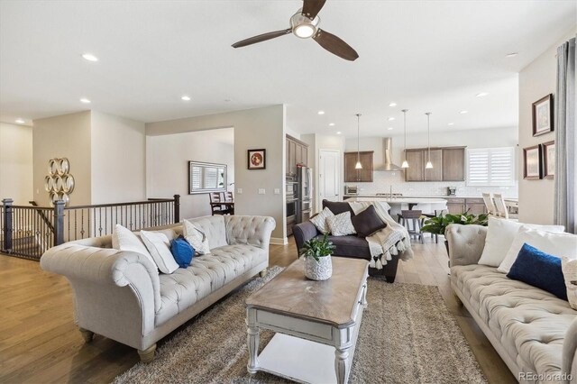 living room with a ceiling fan, wood finished floors, and recessed lighting