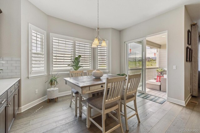 dining room with healthy amount of natural light, light wood-style flooring, and baseboards
