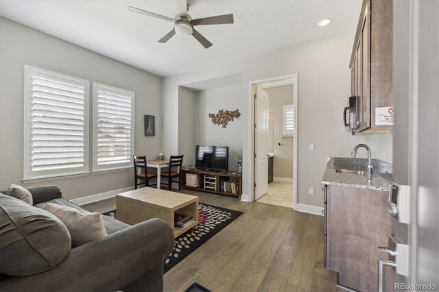 living area featuring a ceiling fan, hardwood / wood-style flooring, baseboards, and recessed lighting