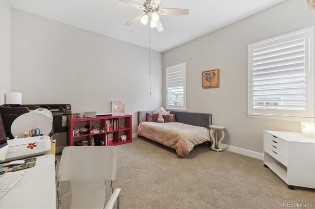 bedroom with light colored carpet, multiple windows, baseboards, and ceiling fan