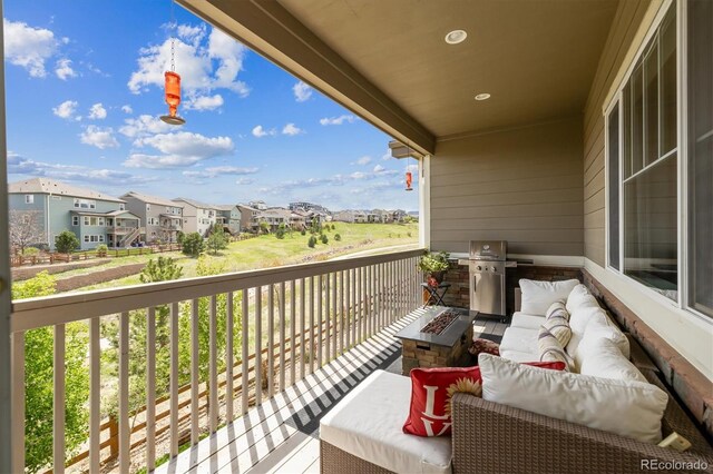 balcony featuring a residential view, an outdoor living space with a fire pit, and area for grilling